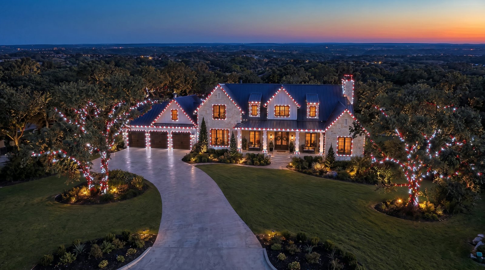 A big Texas home at dusk with snow white and red Christmas lights outlining every roofline, window and tree.